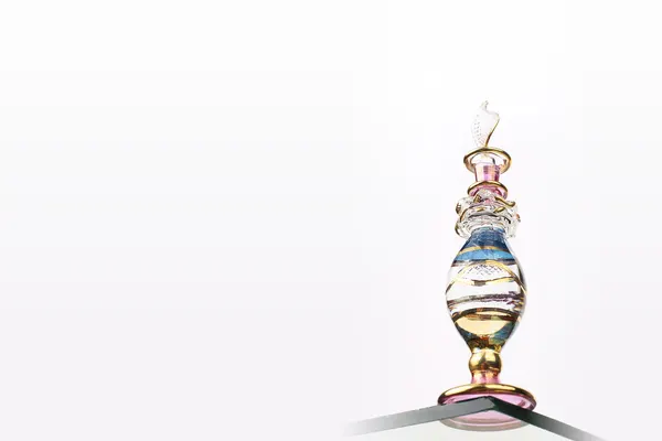 Frasco de perfume de vidro decorado em estilo oriental sobre fundo claro