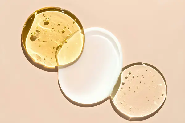 Texturas de sérum, gel e creme sobre fundo nude