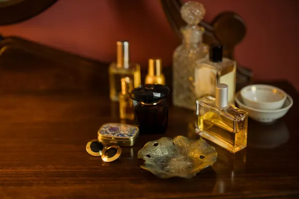 Frascos de perfume de vidro sem marca sobre penteadeira de madeira escura